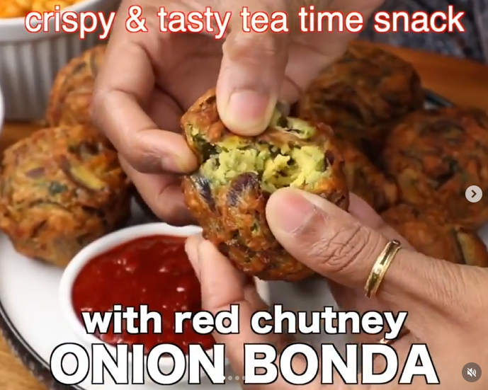Onion bonda with hands pulling it apart to show the inside texture